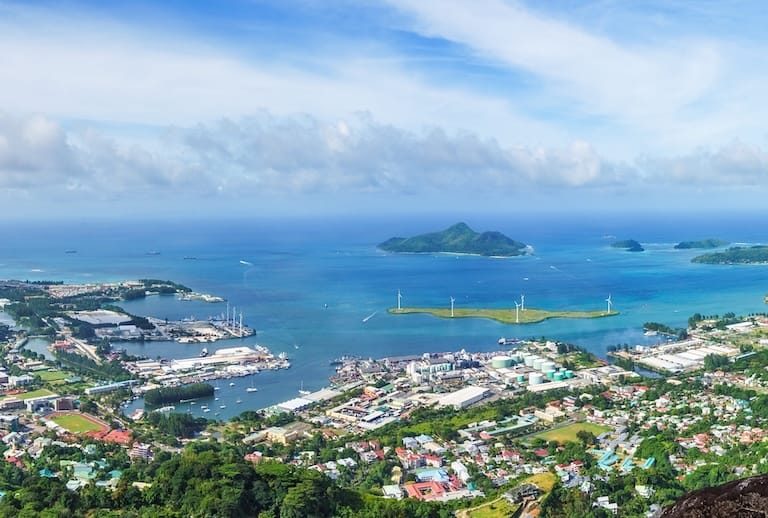 Hiking the copolia trail with granite rocks in the jungle on mahé on the seychelles. Panorama viw of victoria and eden city